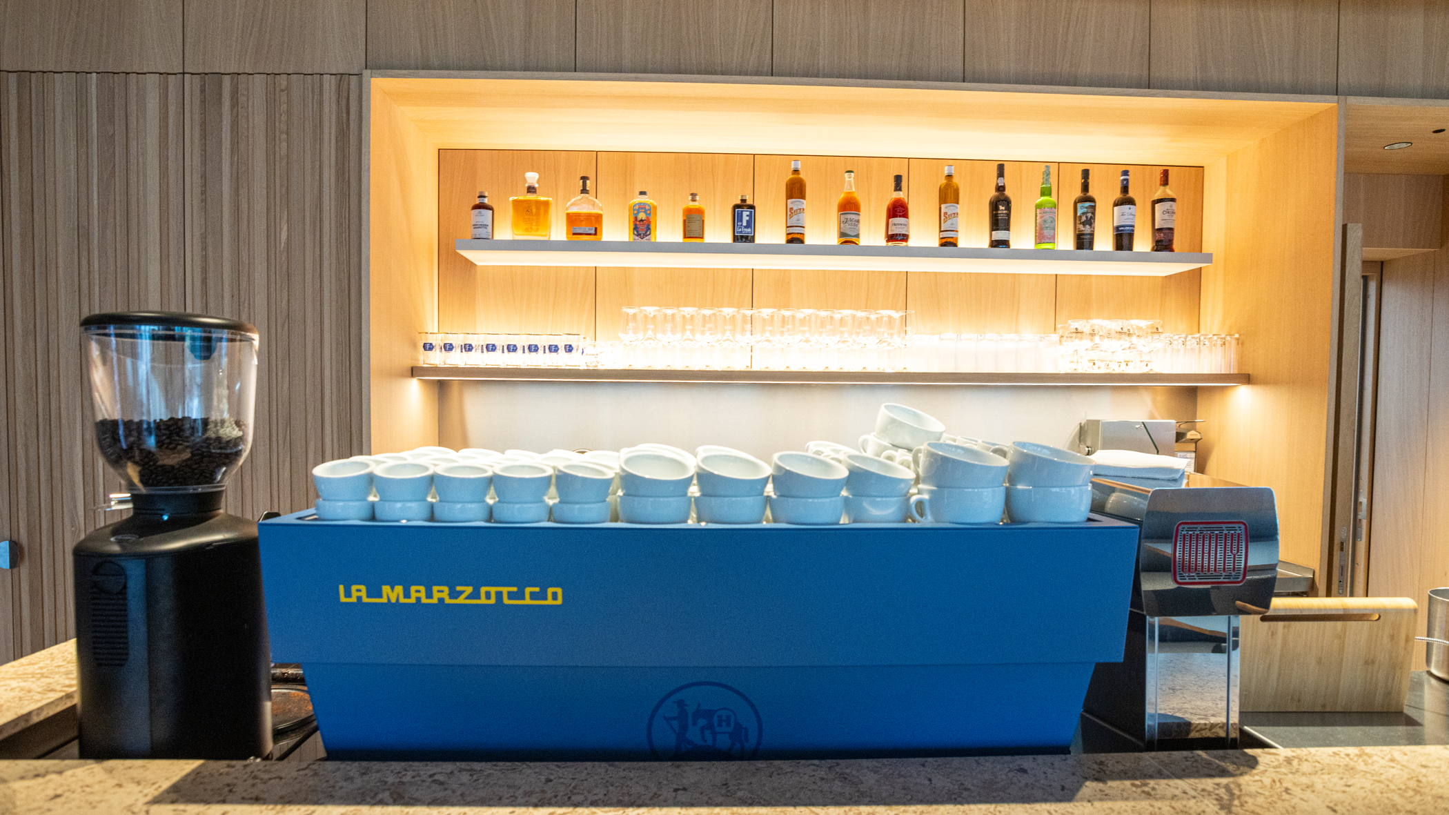 Theke knitz Restaurant,  Große Siebträgermaschine und Kaffeemühle im Vordergrund, im Hintergrund Regal mit Gläsern und verschiedenen Spirituosen.